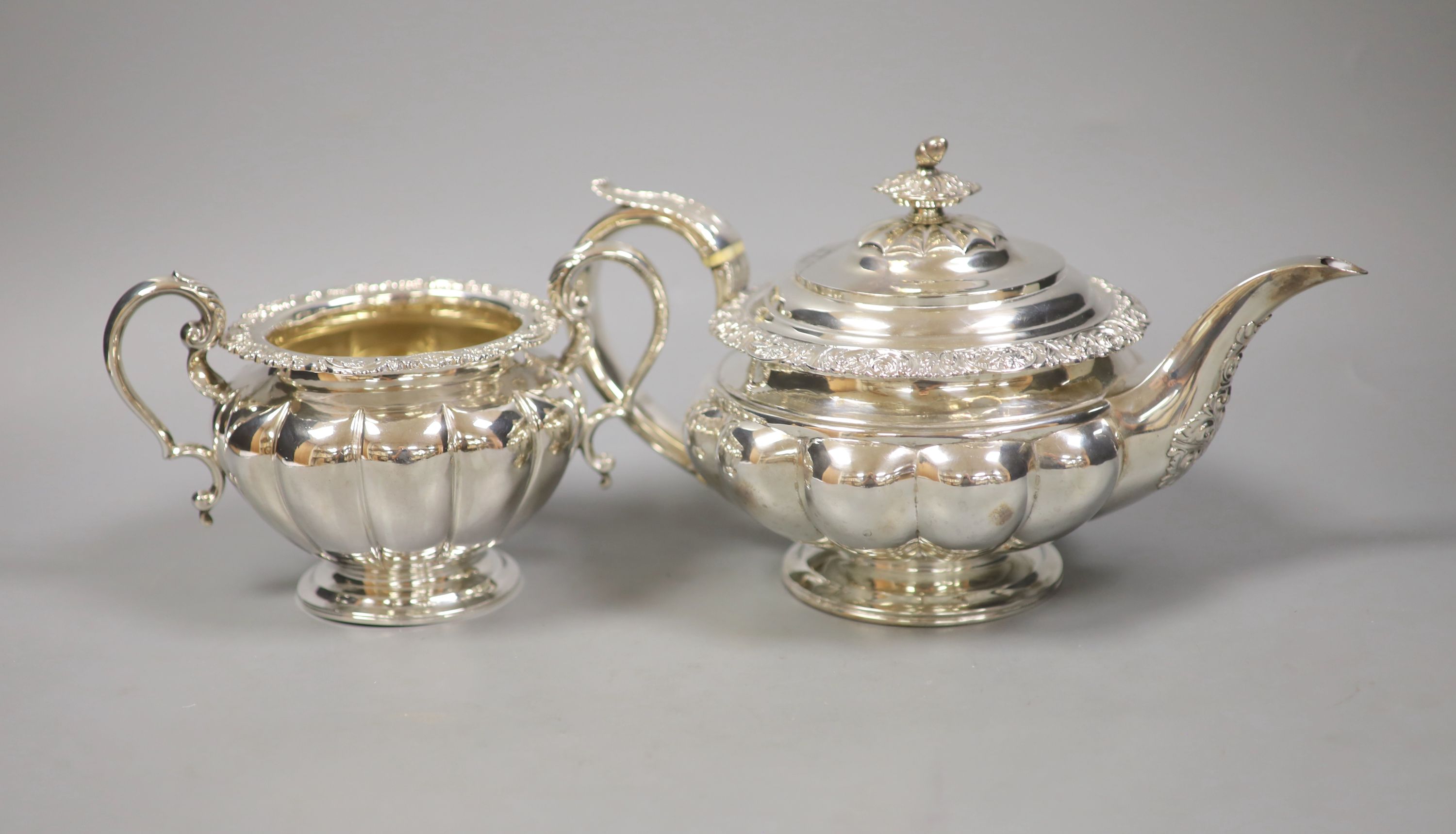 A large Georgian silver teapot, marks rubbed, with an associated twin handled sugar basin, Sheffield, 1864 by Henry Wilkinson & Co
